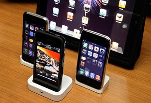 Des iPhone et un iPad disposés sur une table.