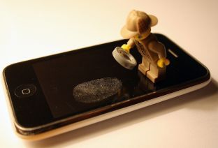 Mise en scène d'un playmobil analysant une empreinte digitale sur un Iphone.